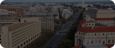 Overhead shot of Washington DC showing federal buildings and tree-lined streets.