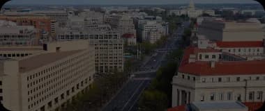 Overhead shot of Washington DC showing federal buildings and tree-lined streets.