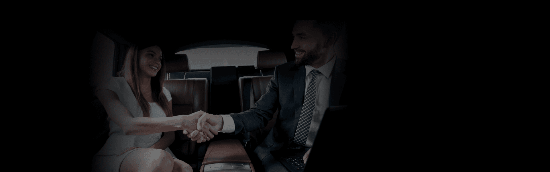 Client & Partner Travel experience shown as two professionals shake hands inside a luxury car's backseat.