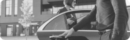 Chauffeur opening a car door for a passenger, representing customizable services.