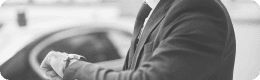 Man adjusting his sleeve near a luxury car, symbolizing timely pickup and dropoff.